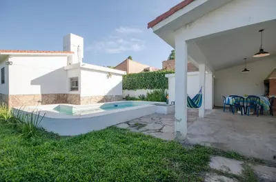 a backyard with a swimming pool and a house at Casa en Villa Carlos Paz con Pileta , Quincho y Jardín a Pasos del Centro in Villa Carlos Paz