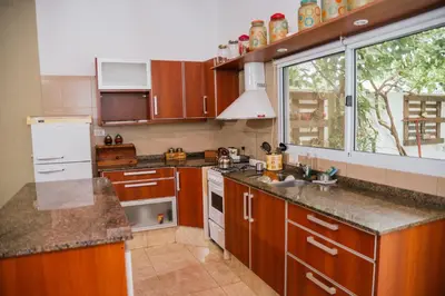 a kitchen with wooden cabinets and a large window at Alojamientos Bolivar in Mina Clavero