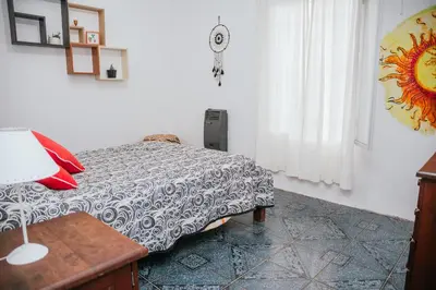 a bedroom with a bed and a table with a lamp at Alojamientos Bolivar in Mina Clavero