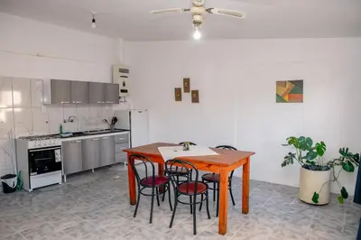 a kitchen with a wooden table and some chairs at Alojamientos Bolivar in Mina Clavero