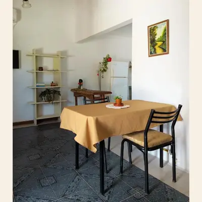 a table with two chairs and aige table cloth on it at Alojamientos Bolivar in Mina Clavero