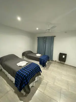 a room with two beds and a television in it at La Herradura Village in Merlo