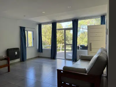 a living room with a couch and large windows at La Herradura Village in Merlo