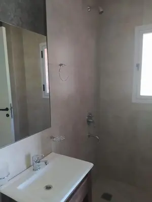 a bathroom with a sink and a shower with a mirror at Casitas Despertar del Valle in Merlo