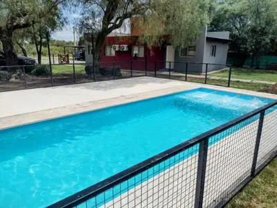 a swimming pool with a fence around it at Casitas Despertar del Valle in Merlo