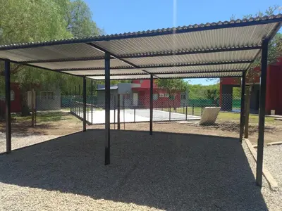 a metal pavilion in a park with a playground at Casitas Despertar del Valle in Merlo