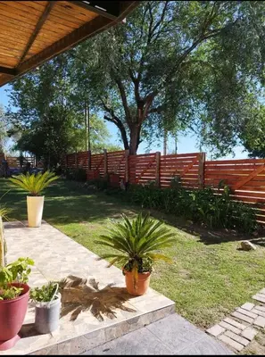 a fence with potted plants in a yard at Cabaña Los Algarrobos in Villa Icho Cruz