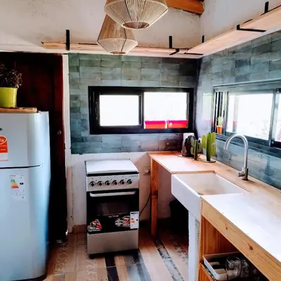 a kitchen with a stove and a sink and a refrigerator at Cabaña Los Algarrobos in Villa Icho Cruz