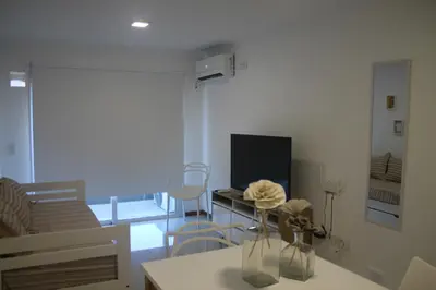 a living room with a couch and a tv at Departamento con piscina y cochera!! Panorámicos de Av Pueyrredón - Güemes -Seguridad 24 hs Terraza - asadores!! in Cordoba