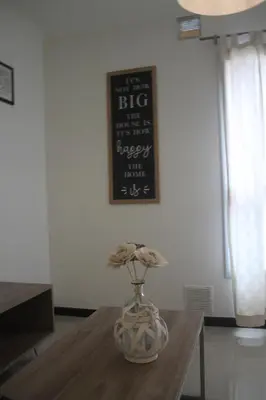 a vase on a table with a sign on the wall at Departamento con piscina y cochera!! Panorámicos de Av Pueyrredón - Güemes -Seguridad 24 hs Terraza - asadores!! in Cordoba