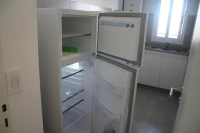 a white refrigerator with its door open in a kitchen at Departamento con piscina y cochera!! Panorámicos de Av Pueyrredón - Güemes -Seguridad 24 hs Terraza - asadores!! in Cordoba