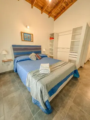 a bedroom with a large bed with blue sheets at Algarrobo Nieto in Merlo