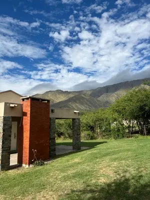 a brick building in a field with mountains in the background at Algarrobo Nieto in Merlo