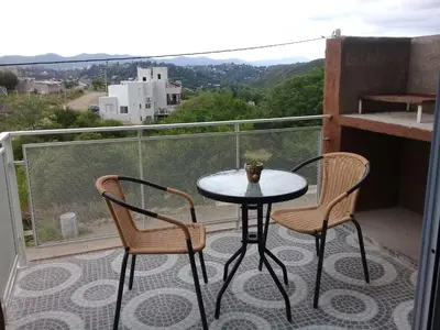 a small table and two chairs on a balcony at Dúplex La Delfina 2 in Villa Carlos Paz