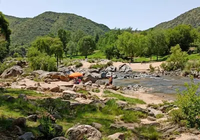 a group of people standing on the rocks by a river at Cabaña El Canal II in Villa Carlos Paz