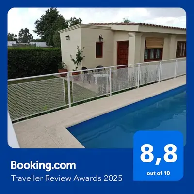 a house with a fence and a swimming pool at Cabaña El Canal II in Villa Carlos Paz