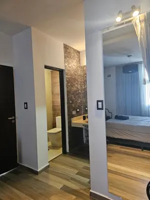 a room with a bed and a bathroom with a mirror at LitStay Caseros con cochera in Cordoba