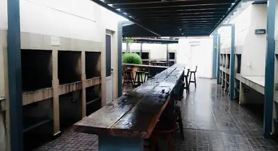 a long wooden bench in a room with tables and chairs at Departamento Villa Carlos Paz Miralejos 3 in Villa Carlos Paz