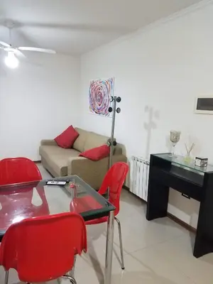 a living room with a table and red chairs at Departamento Villa Carlos Paz Miralejos 3 in Villa Carlos Paz