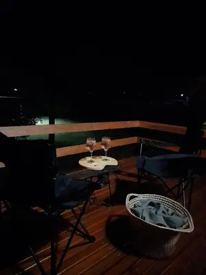 two glasses of wine sitting on a table on a deck at Cabaña Balcón Serrano in Cortaderas