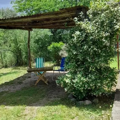 a picnic table and two chairs under a pergola at Cabaña Balcón Serrano in Cortaderas