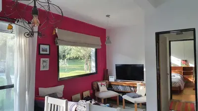 a living room with a red wall and a mirror at ASM CASA I in Merlo