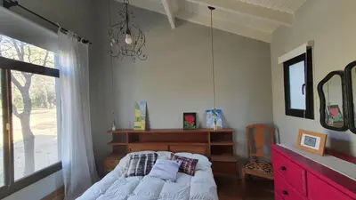 a bedroom with a bed and a window and a chandelier at ASM CASA I in Merlo