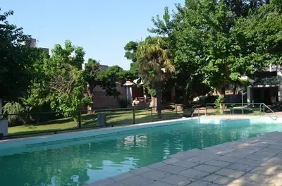 a swimming pool with green water in a yard at HOTEL OLIVIA in Mina Clavero