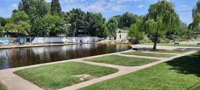 a river with a walkway next to a body of water at HOTEL OLIVIA in Mina Clavero
