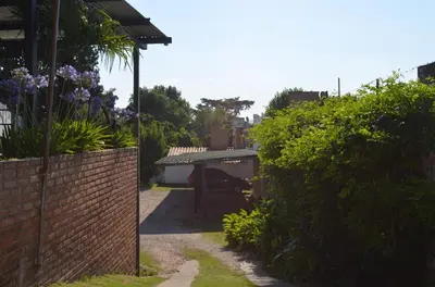 a garden with a brick fence and purple flowers at HOTEL OLIVIA in Mina Clavero