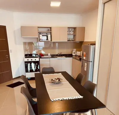 a kitchen with a table and chairs in a room at Departamento frente al lago en Villa Carlos Paz in Villa Carlos Paz