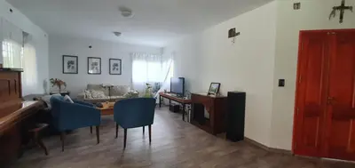 a living room with a table and blue chairs at Casa Sierras de Córdoba Villa el Diquecito in La Calera