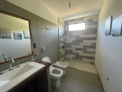 a bathroom with a sink and a toilet and a mirror at Casa Sierras de Córdoba Villa el Diquecito in La Calera