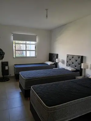 a hotel room with two beds and a window at La casa de Clo in Villa Carlos Paz