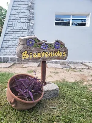 a sign in front of a house with a flower pot at La casa de Clo in Villa Carlos Paz