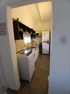a kitchen with a white refrigerator and a sink at La casa de Clo in Villa Carlos Paz