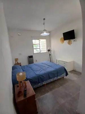 a bedroom with a blue bed and a television at La casa de Clo in Villa Carlos Paz