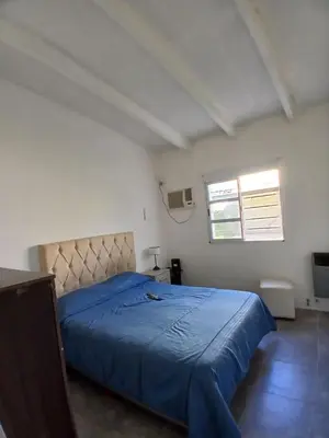 a bedroom with a bed with a blue blanket at La casa de Clo in Villa Carlos Paz