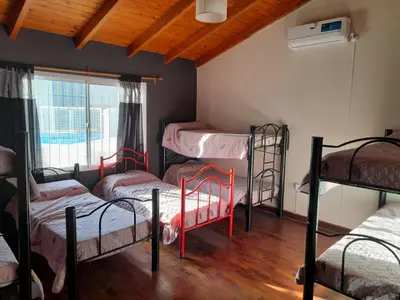 a room with four bunk beds and a window at Casa Villa del Lago in Villa Carlos Paz