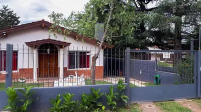 a house with a fence in front of it at Casa Villa del Lago in Villa Carlos Paz