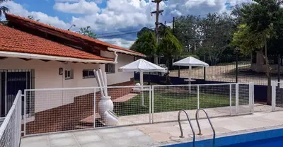 a fence in front of a house with a swimming pool at Casa Villa del Lago in Villa Carlos Paz
