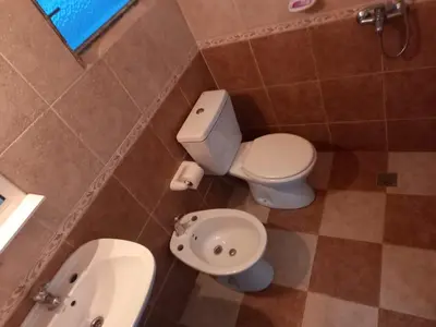 a bathroom with a toilet and a sink at Chalet Centrico in Merlo