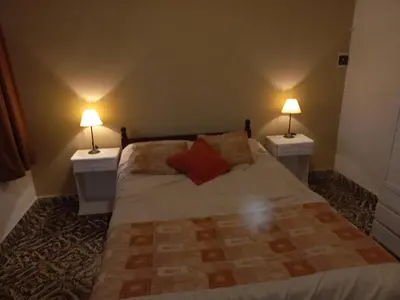 a bedroom with a bed with two lamps on both sides at Chalet Centrico in Merlo
