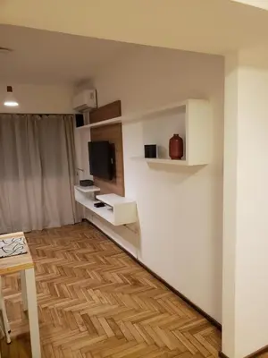 a room with white walls and a table and a television at Departamento de Antonia in Cordoba