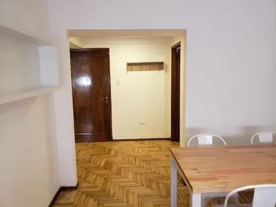 a dining room with a table and chairs and a door at Departamento de Antonia in Cordoba