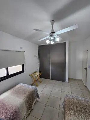 a room with two beds and a ceiling fan at Apartamento Esquiu H in Villa Carlos Paz
