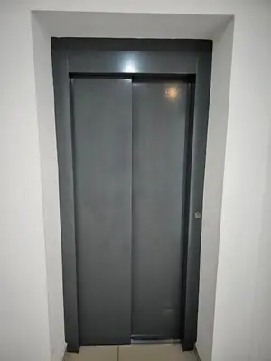 a gray elevator door in a white room at Apartamento Esquiu H in Villa Carlos Paz
