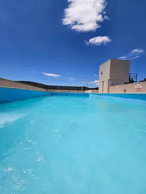 a swimming pool with a building in the background at Apartamento Esquiu H in Villa Carlos Paz