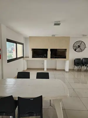 a room with a table and chairs and a clock at Apartamento Esquiu H in Villa Carlos Paz