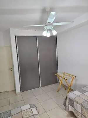 a room with a ceiling fan and sliding glass doors at Apartamento Esquiu C in Villa Carlos Paz